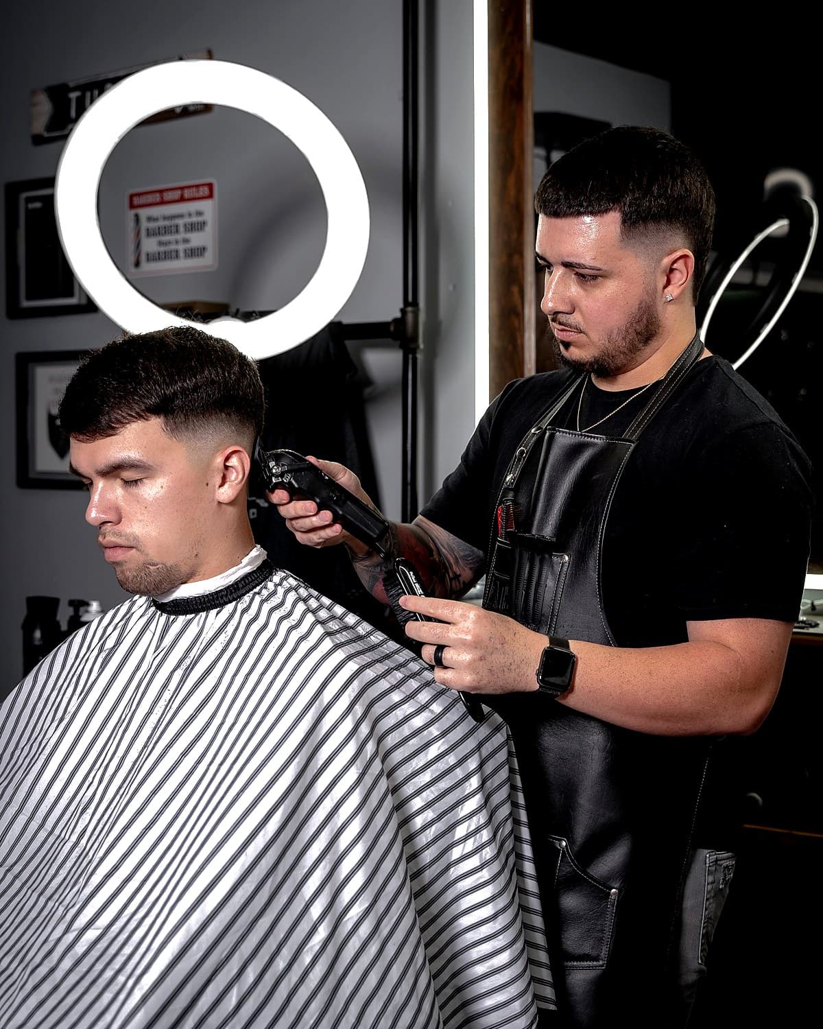 Austin Knox fading a client under the ring light at Vanzant Barbershop Lounge