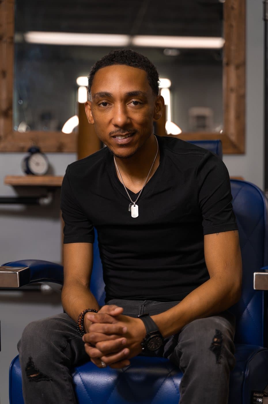 Steve Vanzant, owner of Vanzant Barbershop Lounge, seated in a barber chair