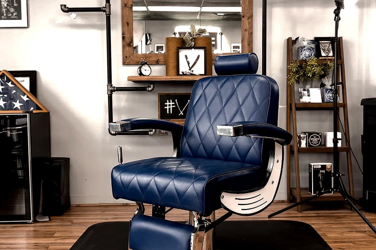 Blue barber chair at a station inside Vanzant Barbershop Lounge