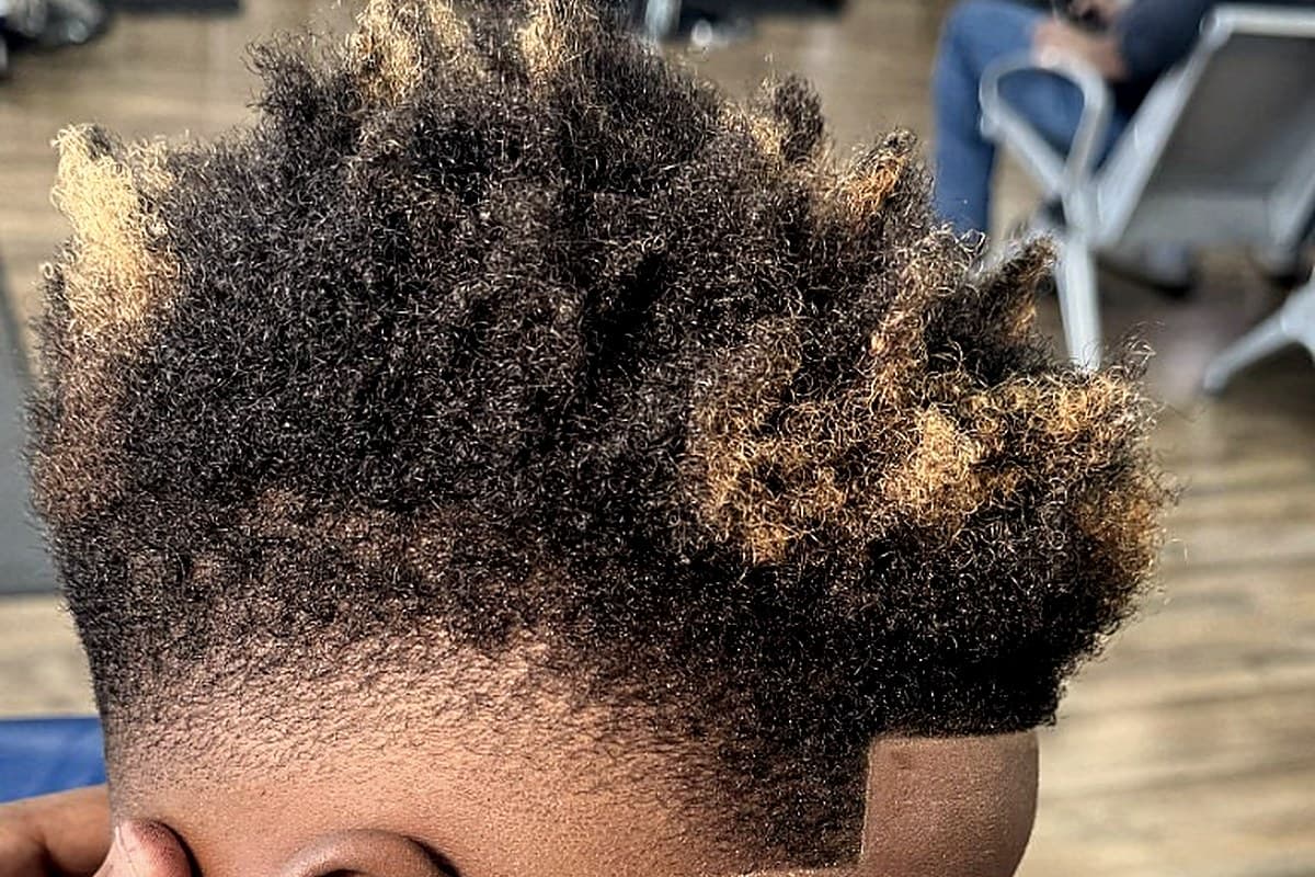 Kid's curly fade with blonde tips finished at Vanzant Barbershop Lounge