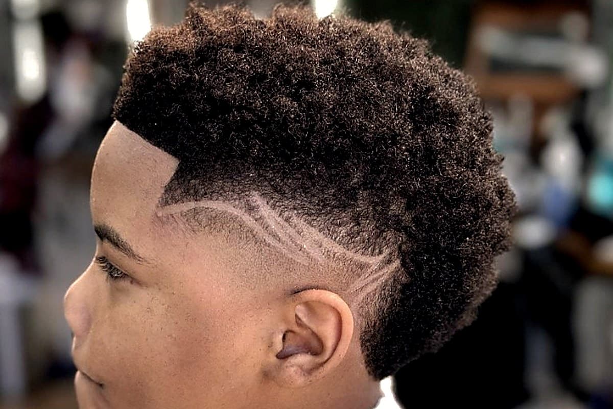 Kid's coiled fade with custom side design at Vanzant Barbershop Lounge