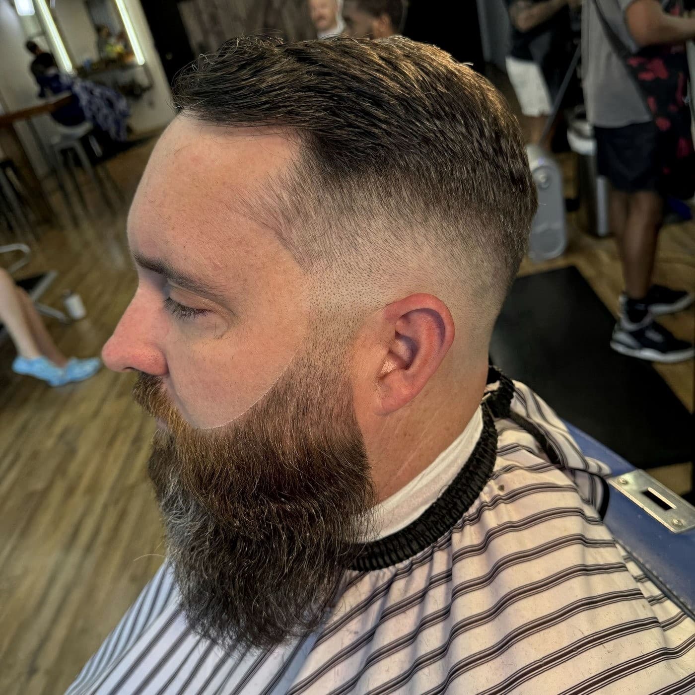 High skin fade with razor-sharp beard line in profile