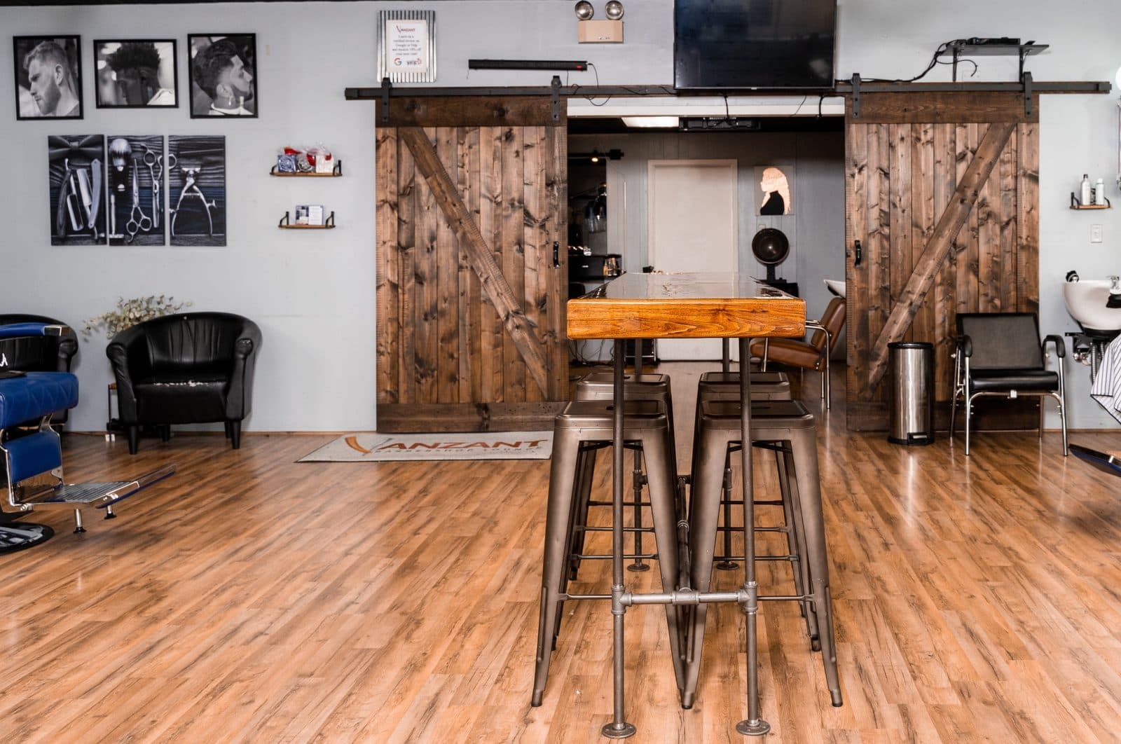 Lounge seating and barn-door interior at Vanzant Barbershop Lounge in Tupelo