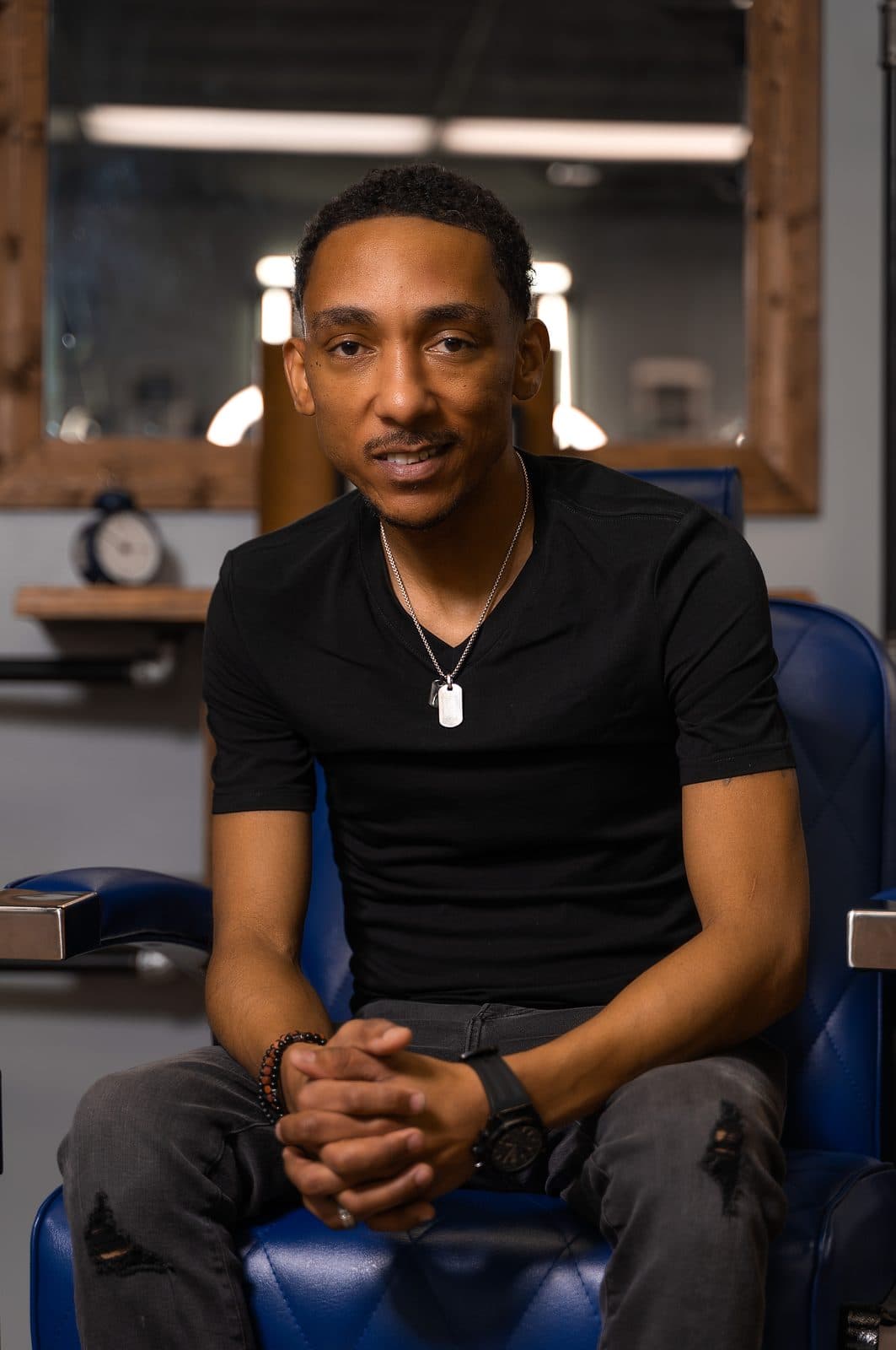Steve Vanzant seated in a blue barber chair at the lounge