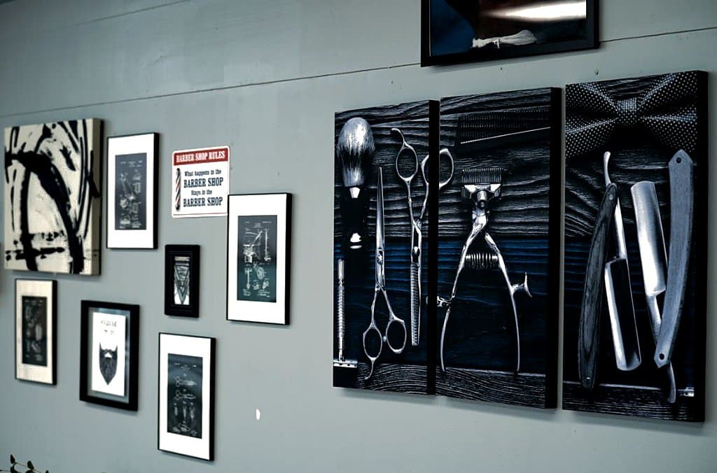 Gallery wall with barber-tool triptych and framed shop art at Vanzant