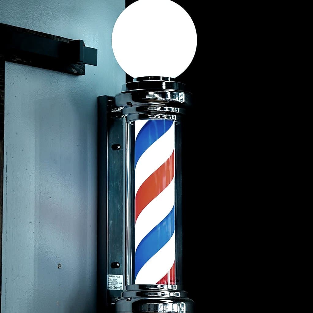 Classic illuminated barber pole at Vanzant Barbershop Lounge