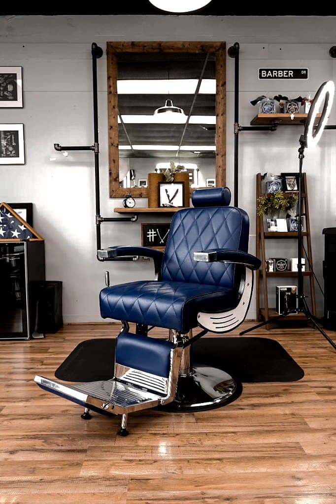 Blue barber chair with ring light and product shelf at Vanzant Barbershop Lounge