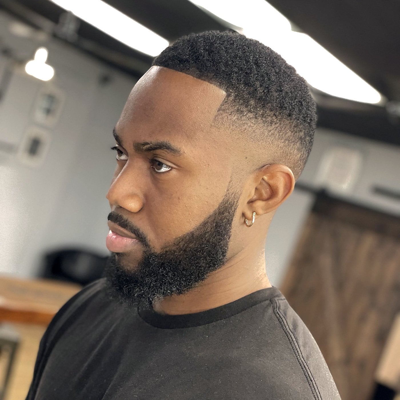 Skin fade with sculpted beard lineup and clean cheek edges