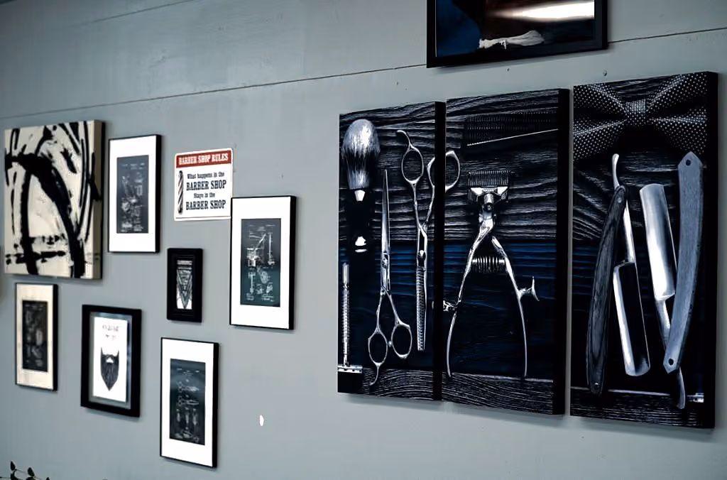 Gallery wall with barber-tool triptych and framed shop art at Vanzant